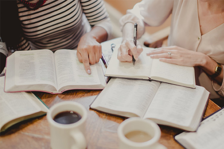 what is discipleship, women studying with open bibles and journals and coffee cups