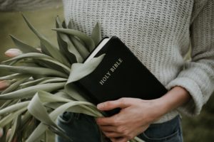 Woman holding Bible and tulips