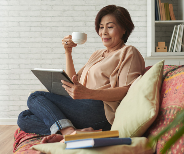 Woman drinking coffee wile on her tablet