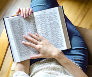 Woman sitting in floor reading Bible