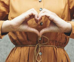 Girl standing with hands in heart shape