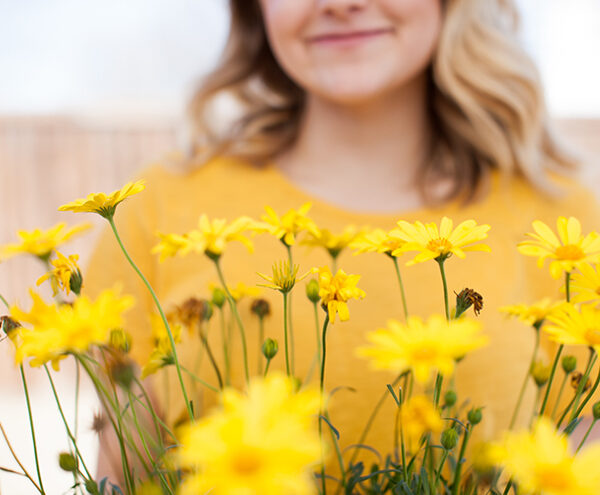 woman holding yellow flowers