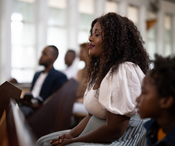 Woman praying for her pastor